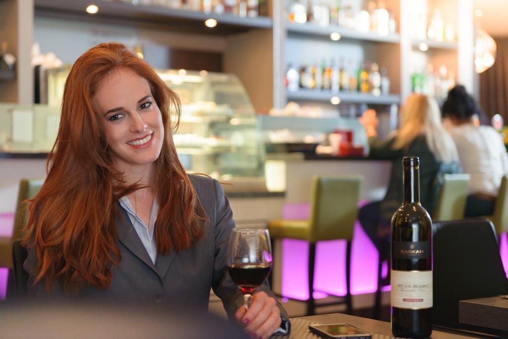 Leonardo City Tower Hotel Tel Aviv Giv'atayim Zewnętrze zdjęcie A woman drinking wine